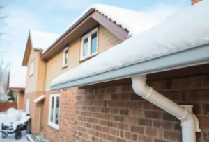 Home winterization strategies with snow-covered roof and gutters